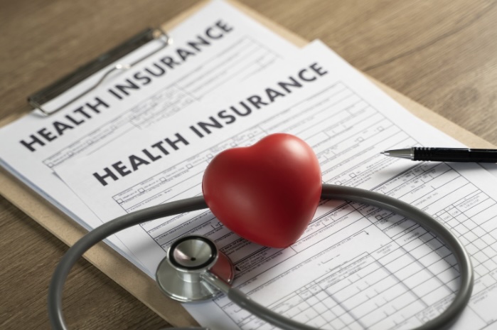 Stethoscope, heart-shaped toy, and health insurance document